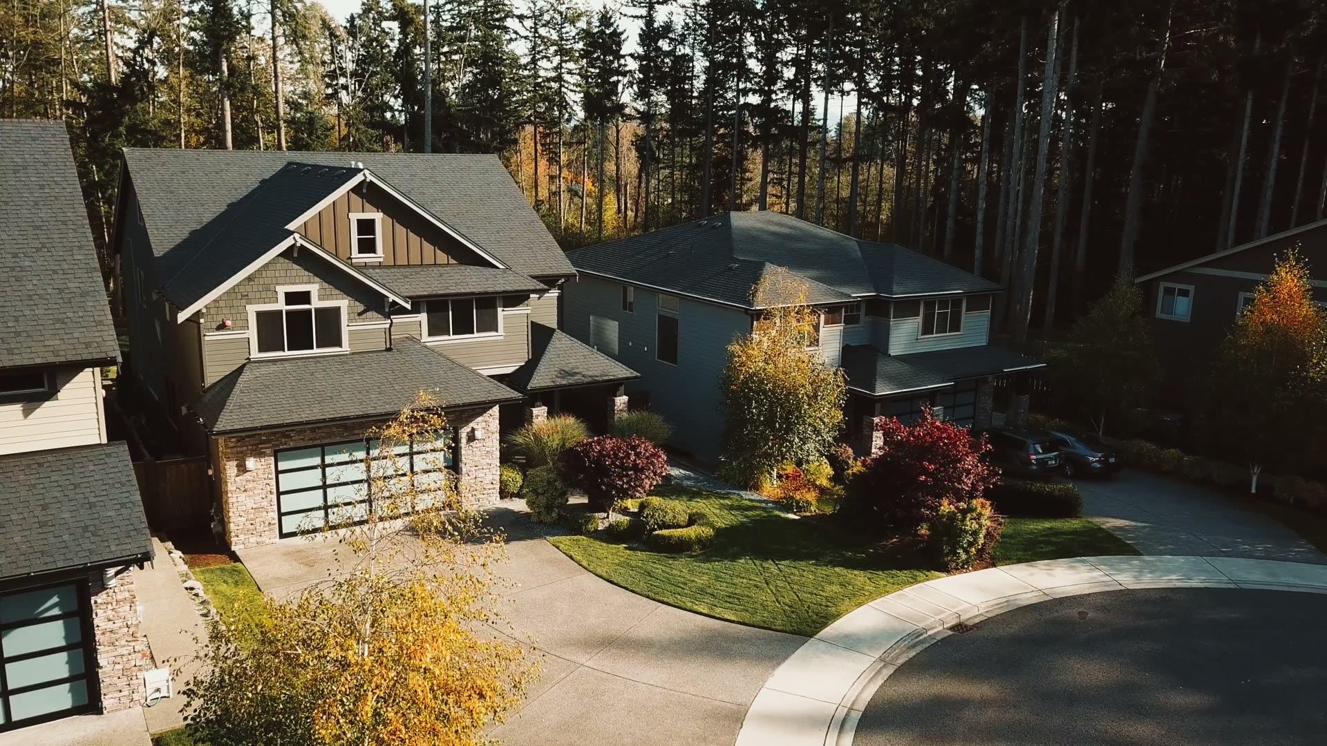 Aerial view of craftsman-style homes on a tree-lined street in autumn